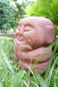 Boo: Steinmetzarbeit aus Sandstein gehauen. Kleine, hockende Figur.